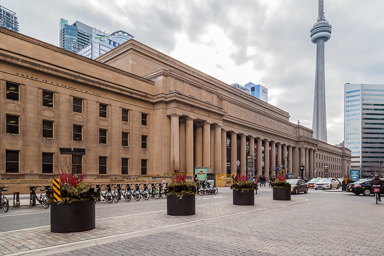 A grand limestone building with large doric columns and classical decorative elements.